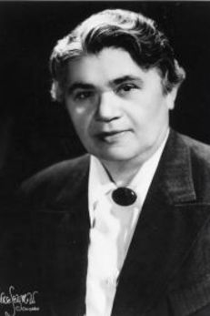 Black and white portrait of Pearl M. Hart, a trailblazing Jewish American attorney known for her advocacy in civil rights and legal defense. She is depicted in a professional setting wearing a dark jacket over a light blouse with a large lapel pin. Her expression is serious and determined, reflecting her significant impact on legal aid and LGBTQ rights during her career, showcasing her as a formidable and pioneering figure in American legal history