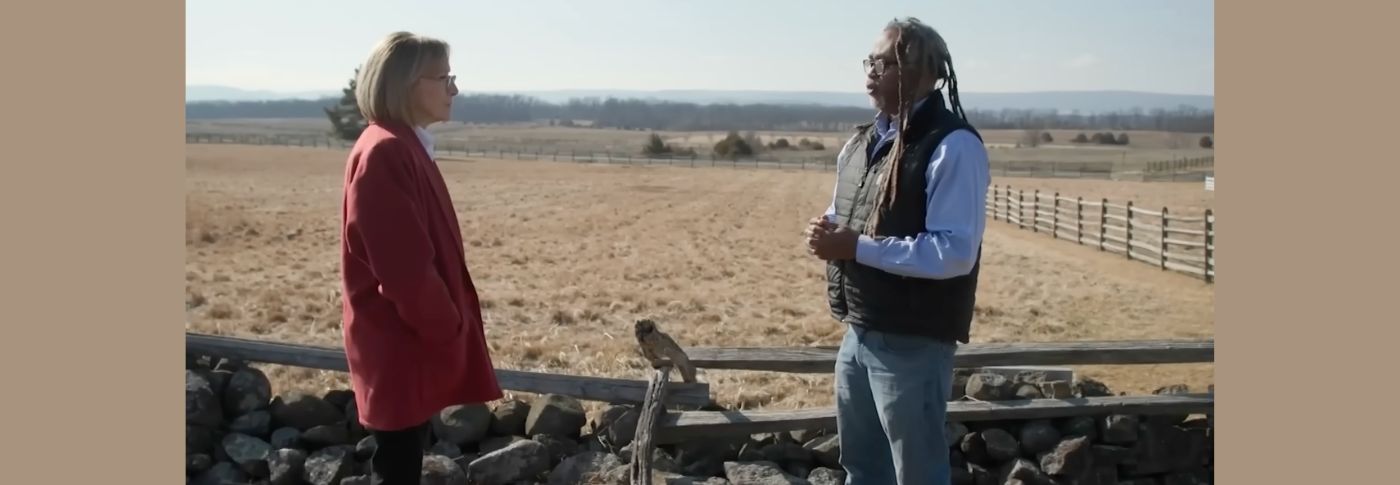 Judy Woodruff and Alan Spears of the National Parks Conservation Association speak outdoors near a historic landscape while discussing Americans’ differing views on the nation’s history ahead of the 250th anniversary.