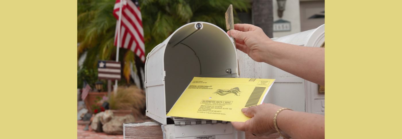 A person places a mail-in ballot into a residential mailbox, as the Supreme Court considers a case that could affect voting rules in upcoming midterm elections.