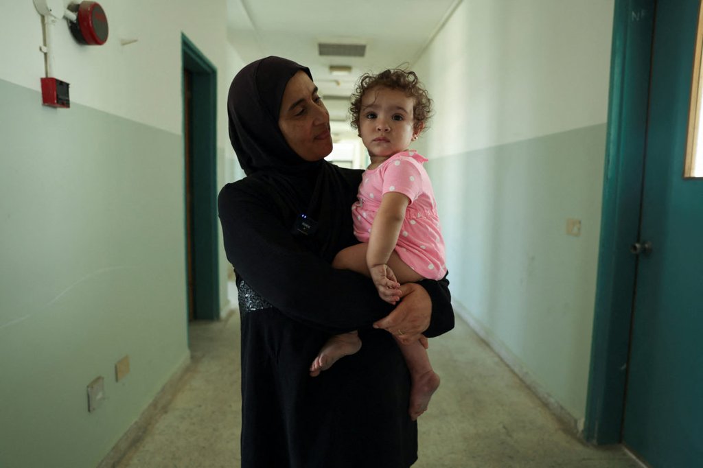 Rima Ali Chahine, a 50-year-old woman who fled from southern Lebanon, holds her granddaughter Matilda, in a hallway of the Technical Institute of Bir Hassan which has been turned into a shelter, amid the ongoing cross-border hostilities between Hezbollah and Israeli forces, in Beirut, Lebanon September 24, 2024. REUTERS/Emilie Madi