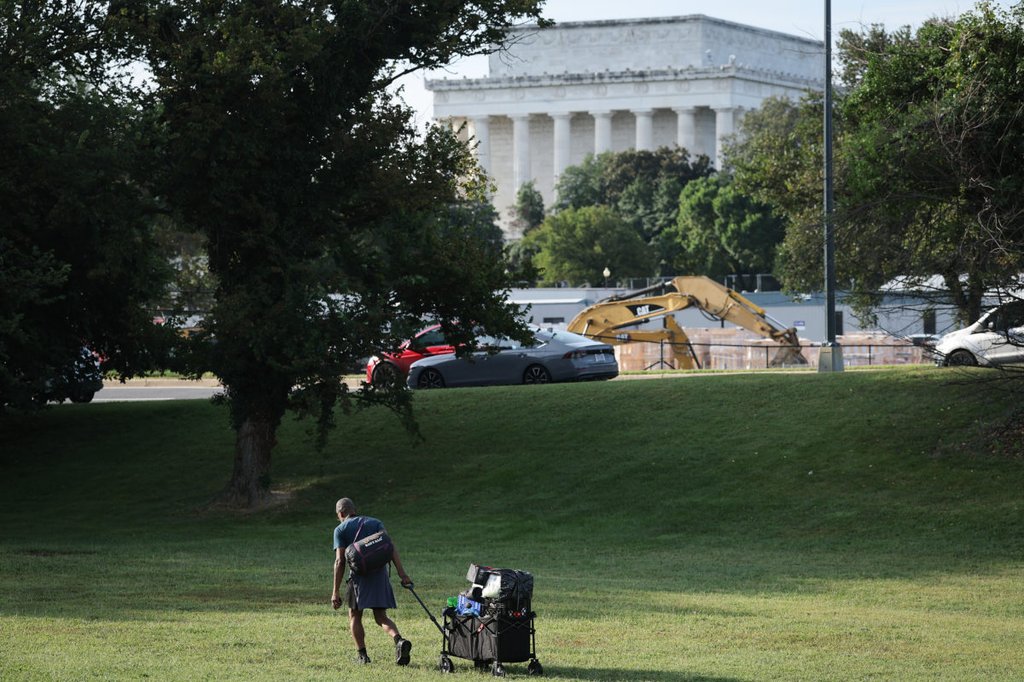 A man clears his belongings from a homeless encampment near the Lincoln Memorial August 14, 2025 in Washington, DC. Photo by Win McNamee/Getty Images