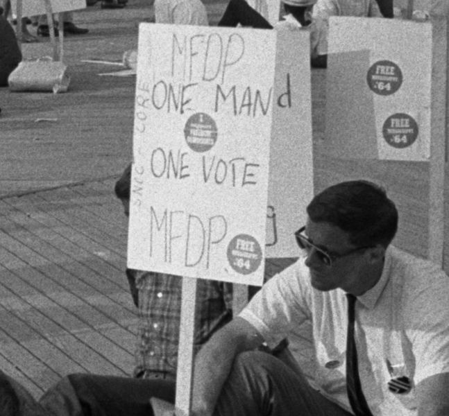 African American and white supporters of the Mississippi Freedom Democratic Party holding signs in front of the convention hall at the 1964 Democratic National Convention, Atlantic City, New Jersey; some signs read: One man, one vote, MFDP